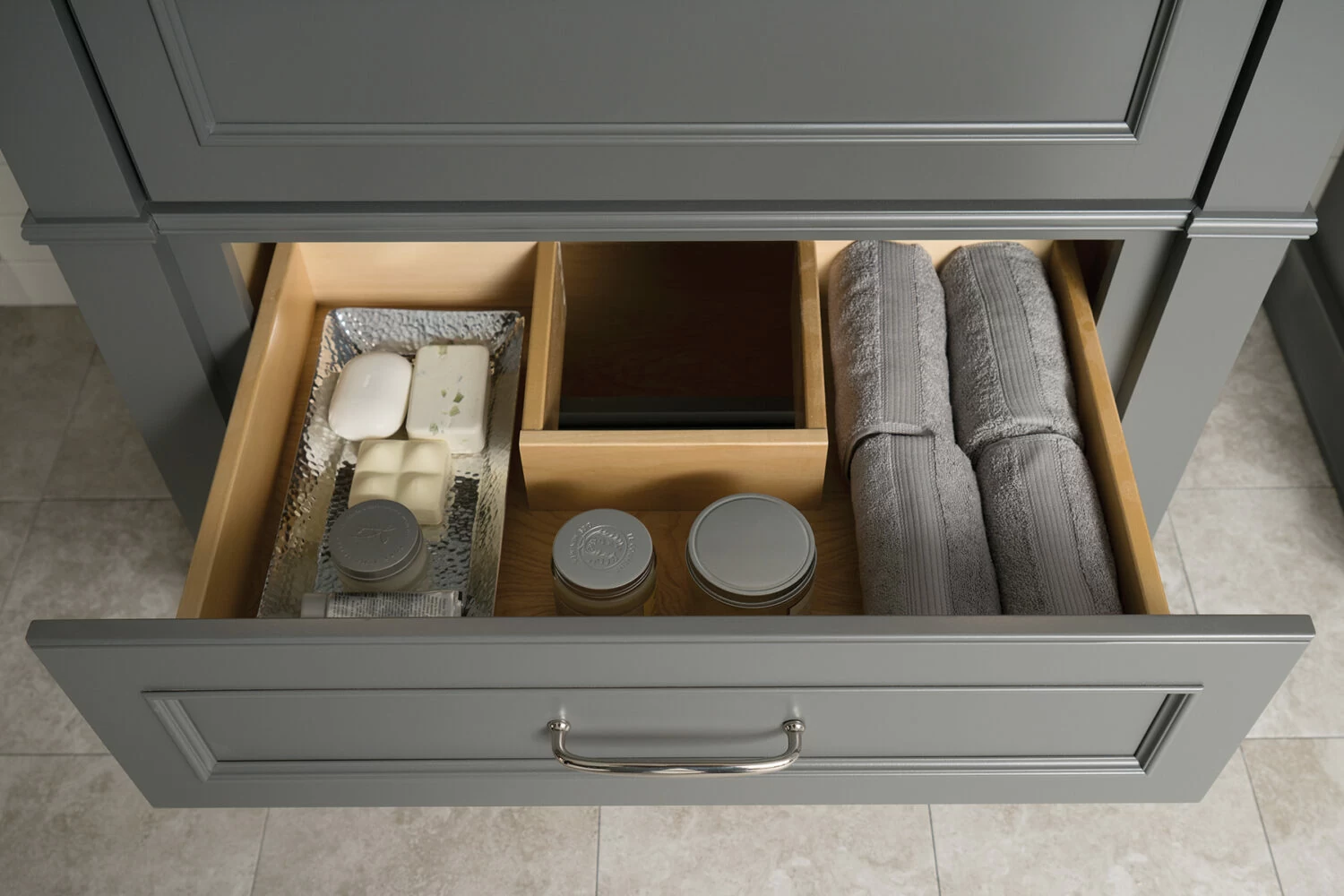 A gray-colored drawer in a bathroom vanity with a sink cut-out for optimal storage