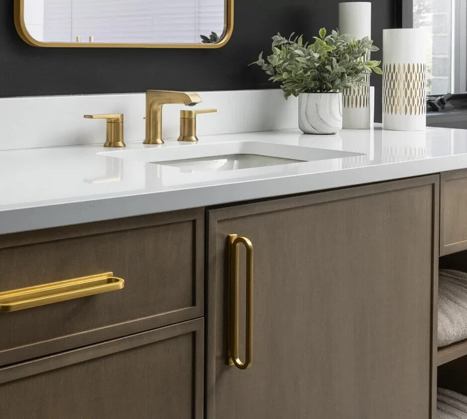 A close-up view of a bathroom vanity with bold, brass hardware
