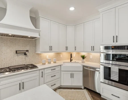 Kitchen cabinets with sink in corner and craftsman style range hood