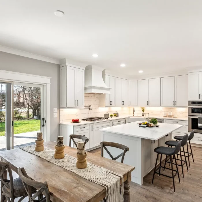 Wide angle shot of a kitchen with white cabinets