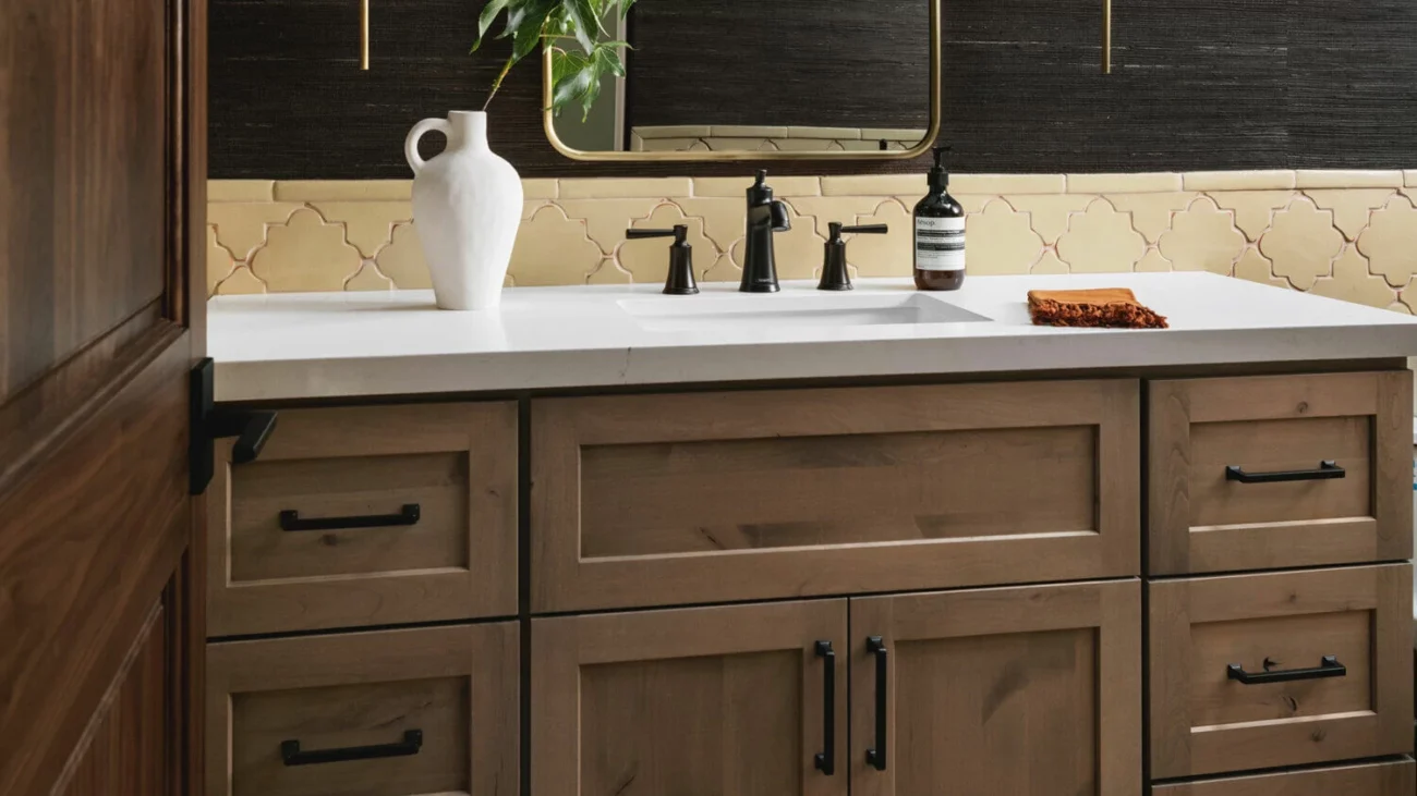 A close up view of a bathroom vanity with unique tile backsplash