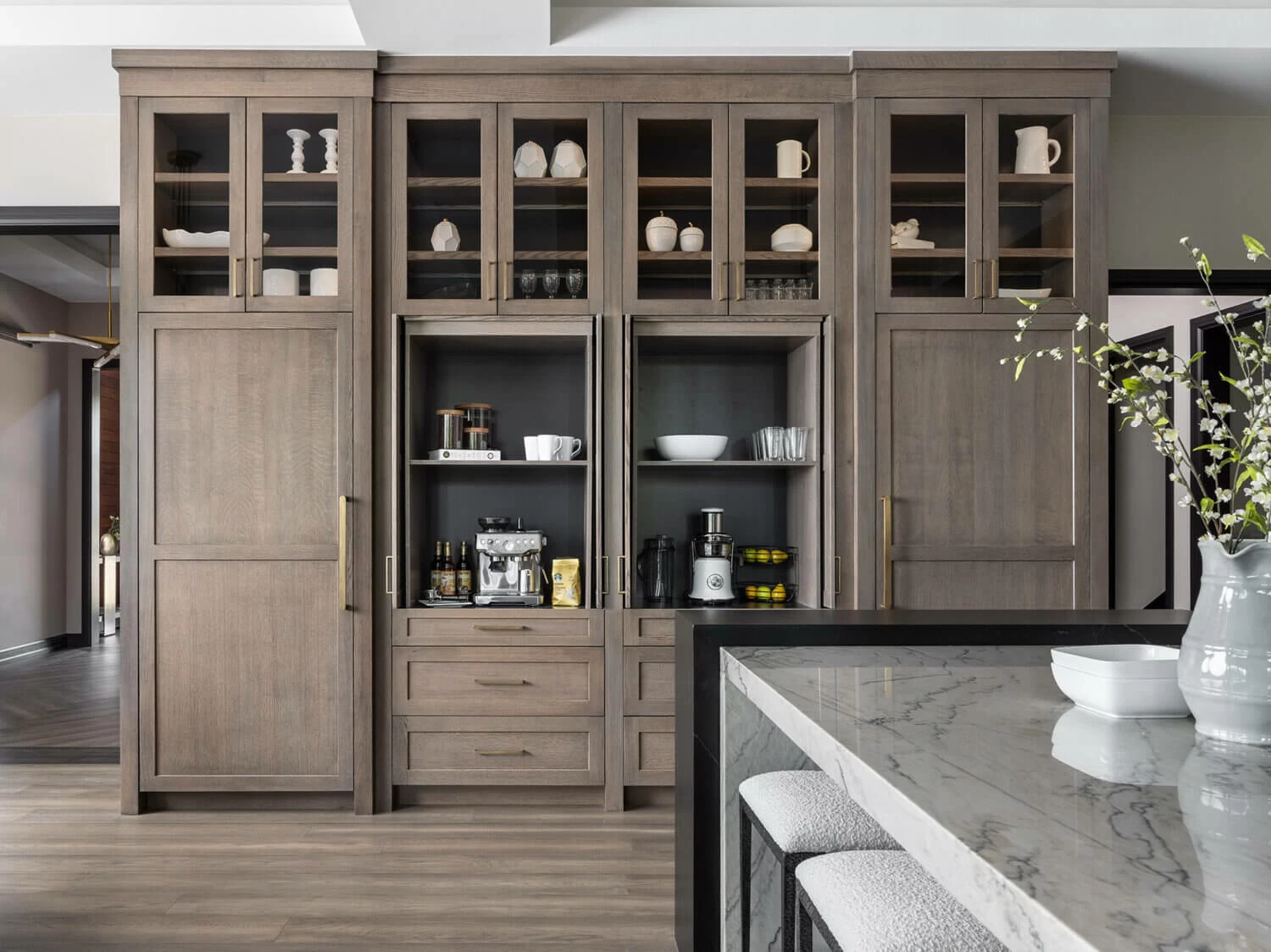 A large wall of pantry cabinets with an inset coffee bar